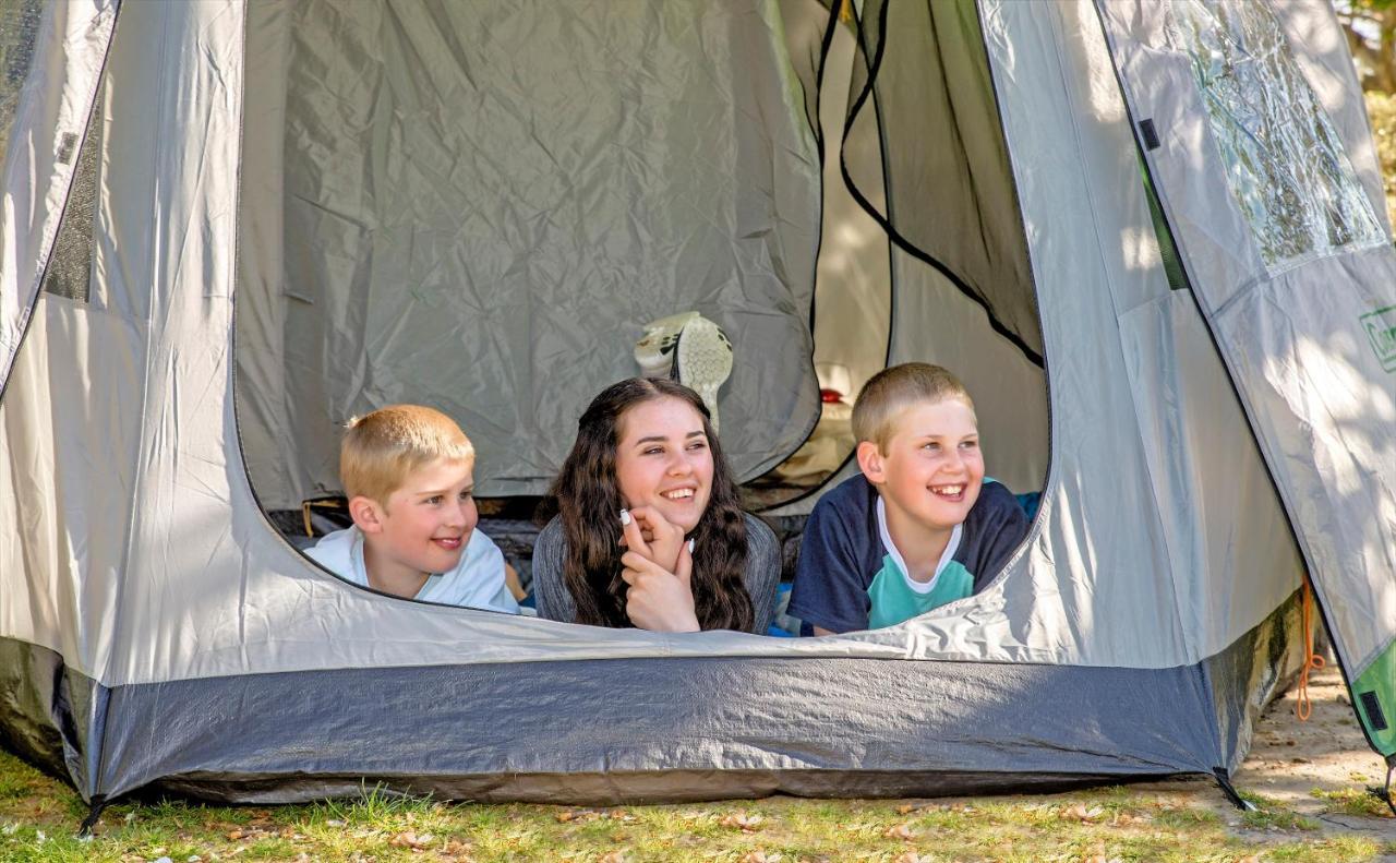 Taupo Debretts Spa Resort Luaran gambar The photo shows three children inside a tent, looking out from an opening. Two boys are on the left, one with short blonde hair and the other with light brown hair, while the girl in the middle has long dark hair. They all appear to be happy and enga